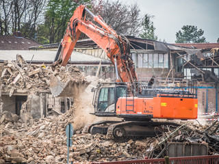 Bagger reisst Fabrikgebäude ab