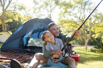 Fotobehang Father and daughter holding a fishing rod outside the tent © wavebreak3