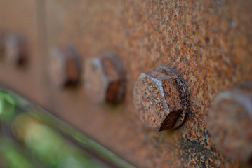Rusty bolts on a steel rail.
