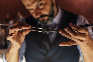 Barman is making cocktail at night club.