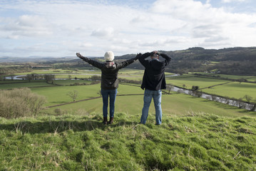 Happy mature couple outdoors over looking a view 