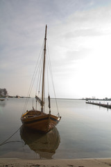Stara łódź żaglowa przy nabrzeżu - obrazy, fototapety, plakaty