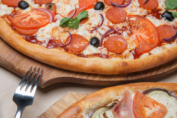 two pizzas on the table next to them and fork