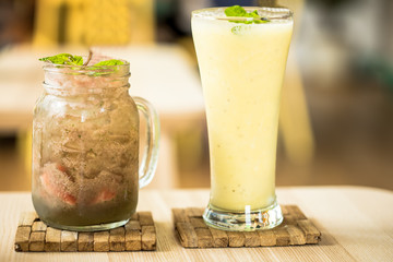 cocktail of pineapple, mango and passion fruit juice with ice on the table