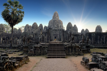 faces, heads of ancient Bayon Temple at Angkor Wat during sunrise, Siem Reap, Cambodia 