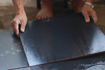 Fototapeta na wymiar Ceramic Tiles. Tiler placing ceramic wall tile in position over adhesive with lash tile leveling system