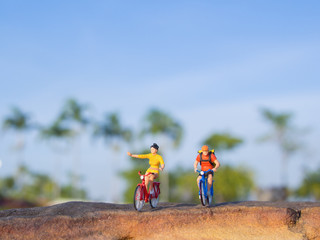 mini figure toys ride bicycle outdoor on the sunny day
