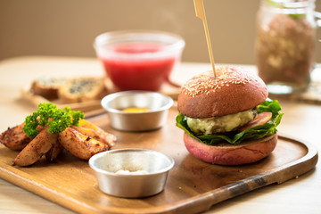 Burger in a pink bun and juicy chop