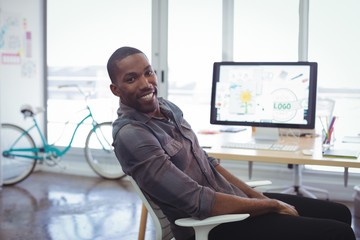 Smiling businessman sitting in brightly lit office