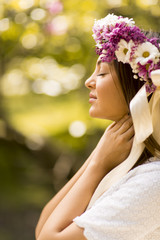 Young woman with flowers in her hair on sunny spring day