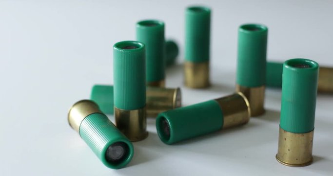 Shotgun slug shells scattered on white surface