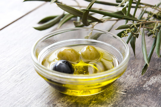Virgin olive oil in a crystal bowl on wooden background
