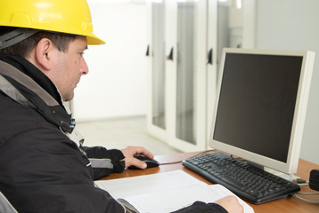 Technician working on the computer  in the power plant control center