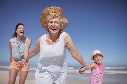 Cheerful multi-generation family at beach - Powered by Adobe