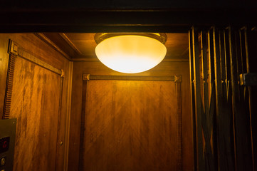 Bright light inside dark wooden lift