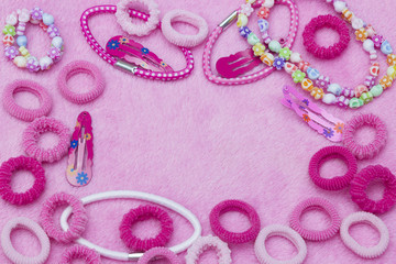 Bright pink cute colorful hair ribbons, bracelet and necklace, hair clips. Girlish teenager style background. A horizontal template for a party design greeting card, with copyspace. Place for text
