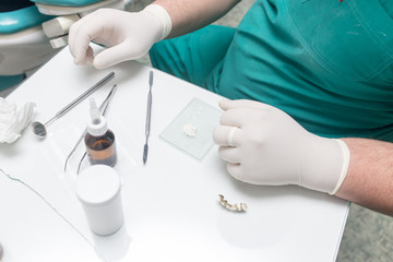 A dentist prepares an implant in the clinic