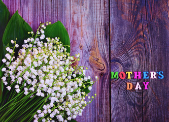 Festive gray wooden background with the inscription Mother's Day