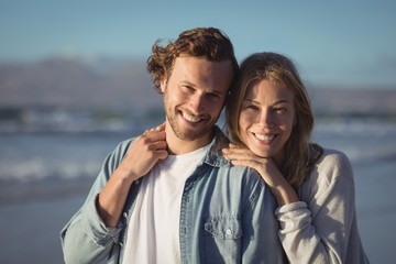 Portrait of smiling couple standing at beach