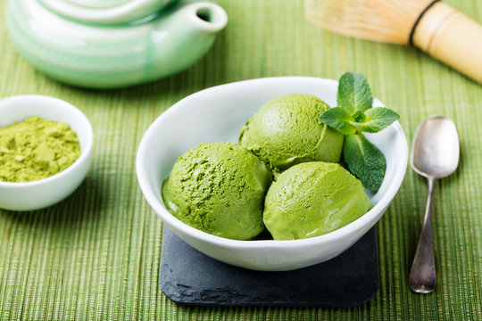 Matcha ice cream in white bowl. Green background.