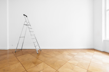 ladder in empty room with white wall and wooden floor