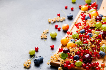 Fresh berries on wooden cutting board. Copy space