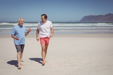 Man talking with his father while walking at beach