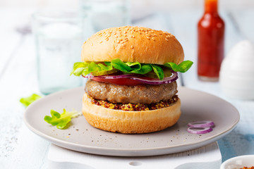 Burger on a plate. Light blue background.