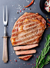 Grilled sliced beef steak on slate table. Top view