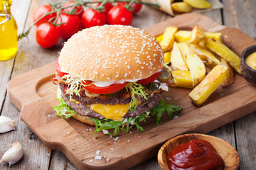 Burger, hamburger, french fries on a cutting board