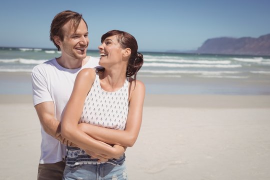 Cheerful couple embracing at beach