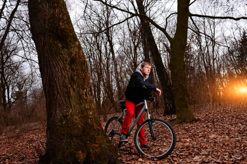 Fototapeta premium Cyclist Riding the Bike on a Trail in Summer Forest