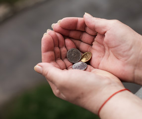 Hands of senior woman with coins, closeup. Poverty concept