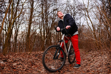 Cyclist Riding the Bike on the Trail in the Beautiful Spring Forest Wide Angle