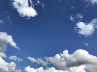 Naklejka na ściany i meble Big white cumulus clouds in the blue sky
