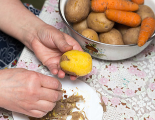Woman cleaning potatoes with her hands