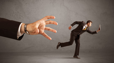 Businessman running from hand
