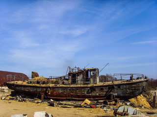 Fototapeta na wymiar An old broken rusty ship on land