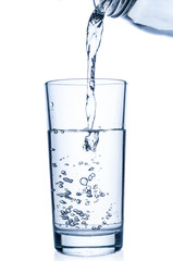 Flowing pure water into glass on white background