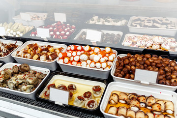 A variety of pickled appetizers, artichokes, Feferoni, in the showcase of street food market