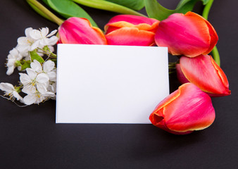 a sign on a black background with red tulips and white flowers