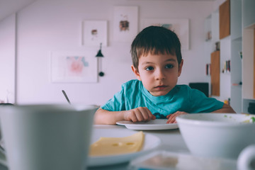 young boy eating without any attention
