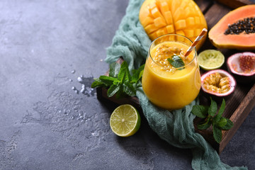 Healthy smoothie with tropical fruits, pineapple, papaya and passion fruit, exotic vitamin drink
