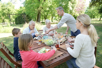 Family having summer lunch in garden