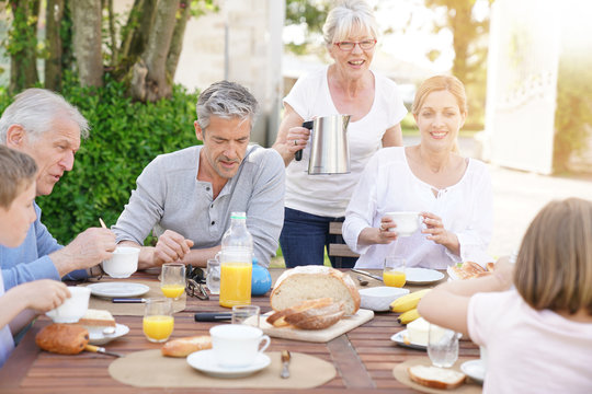 Family of 6 having breakfast together outside the house