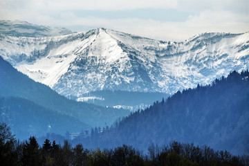 Fototapeta na wymiar Snowy mountains in bavarian alps against cloudy sky, tourist resort landscape in bavaria, germany, europe