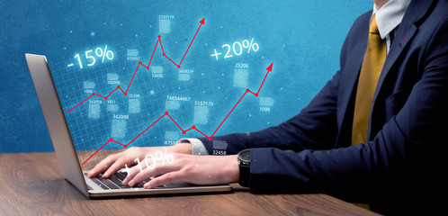 Salesman working on graph with laptop