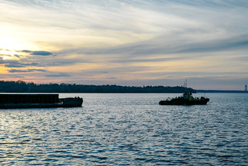 Obraz premium The tug pulls the barge 