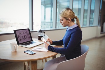 Executive using digital tablet at table