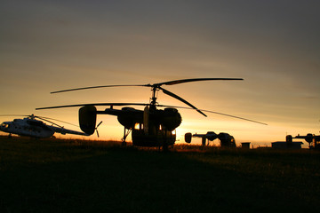 Fototapeta na wymiar dark silhouette of helicopters on a background of sunset sky